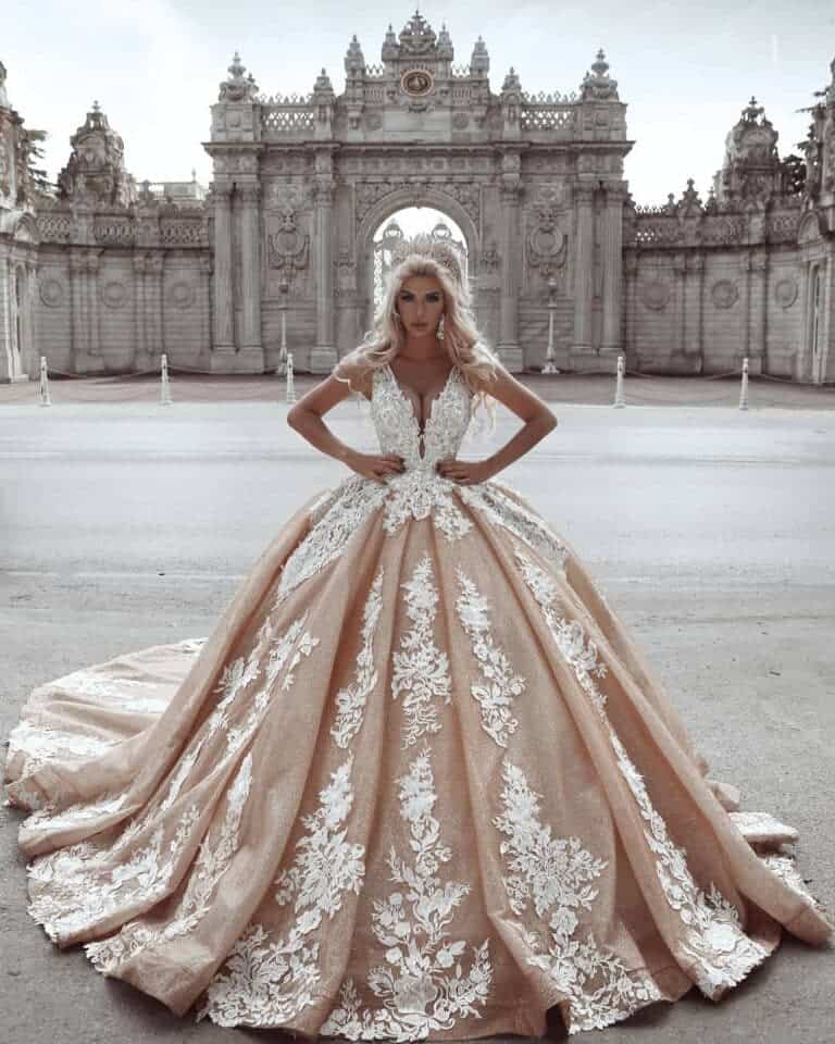 Modelka w eleganckiej sukni ślubnej na tle zabytkowego pałacu.