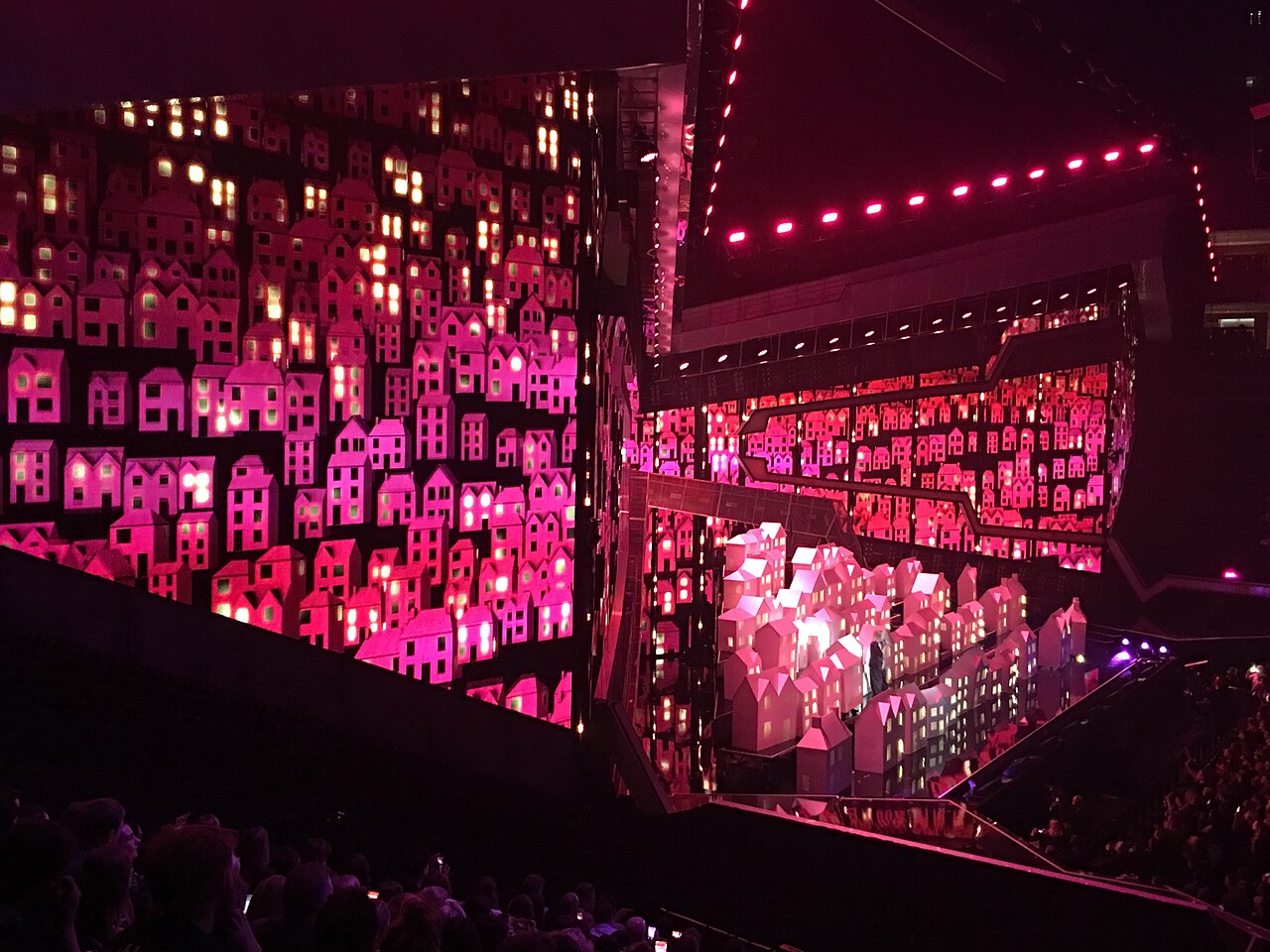 Katy Perry na scenie BRIT Awards 2017 Katy Perry podczas piosenki Chained to the Rhythm na BRIT Awards 2017 w scenografii z domami